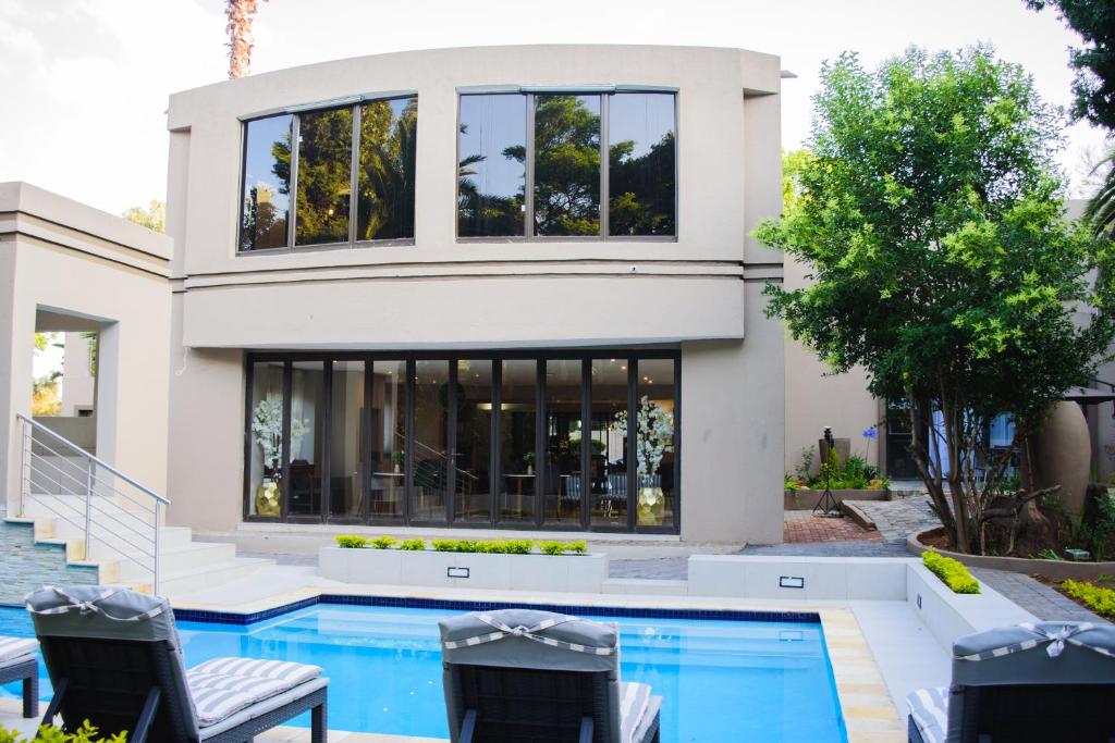 a house with a swimming pool and two chairs at The Hide on Aston-Sandton in Johannesburg
