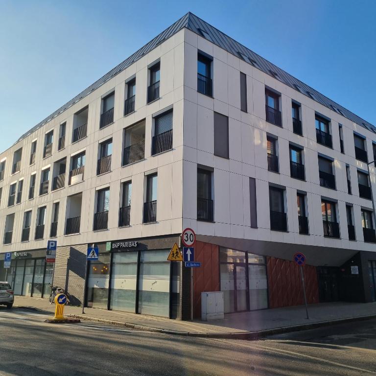 a white building on the corner of a street at Apartament Skarbowa 2 in Leszno