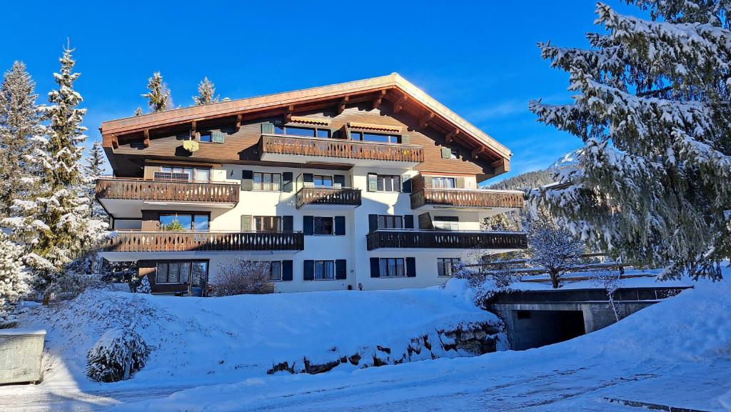 a large building with snow in front of it at Helvetia (388 Sr) 2. Stock in Lenzerheide