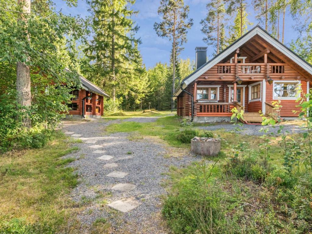 a log cabin in the woods with a path leading to it at Holiday Home Tallukka by Interhome in Pertunmaa