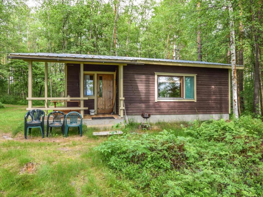 a small house with two chairs in front of it at Holiday Home Leppäranta by Interhome in Harjula