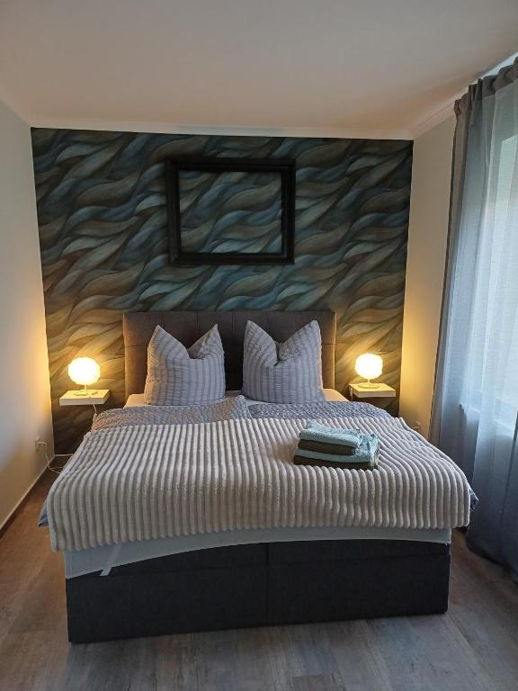 a bedroom with a large bed with a painting on the wall at FeWo Sasa in Blankenburg