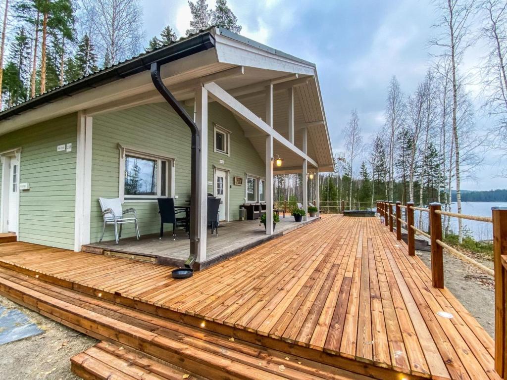 a house with a large wooden deck next to the water at Holiday Home Villa sipilä by Interhome in Savonranta