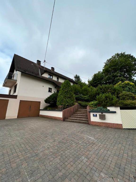 a large white house with a garage and a driveway at Aparts4ring 5 Nürburg in Nürburg