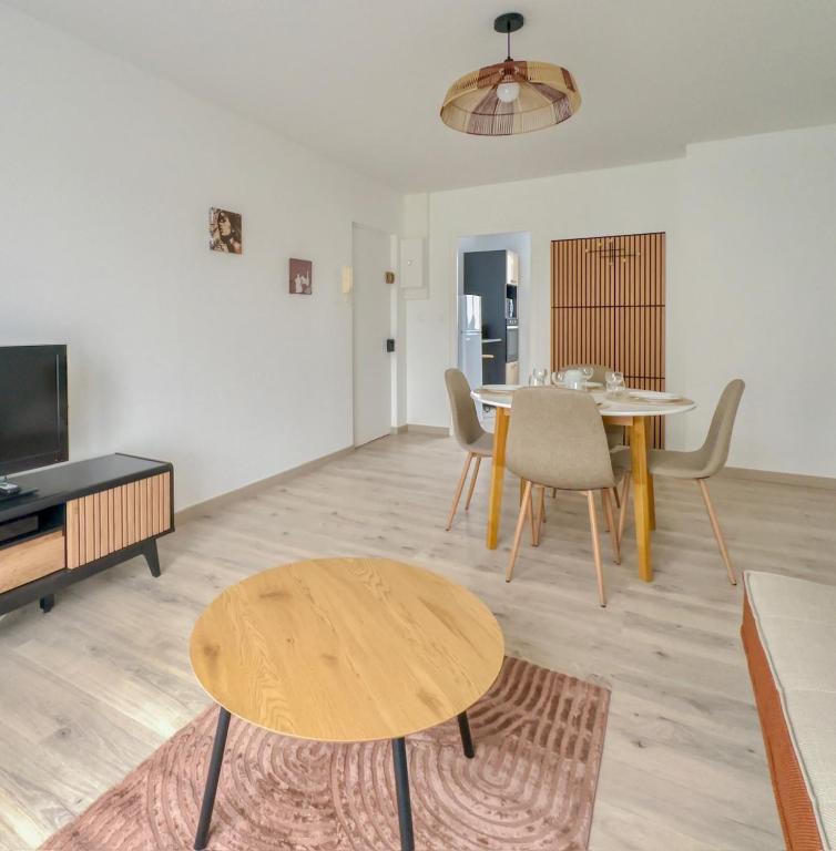 a living room with a table and a couch at Les Peupliers Appart de Charme in Compiègne