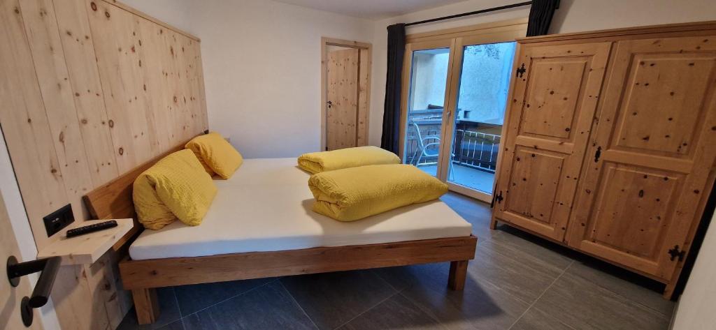 a room with a couch with yellow pillows on it at Alpina Hotel-Apartments in Santa Maria Val Müstair