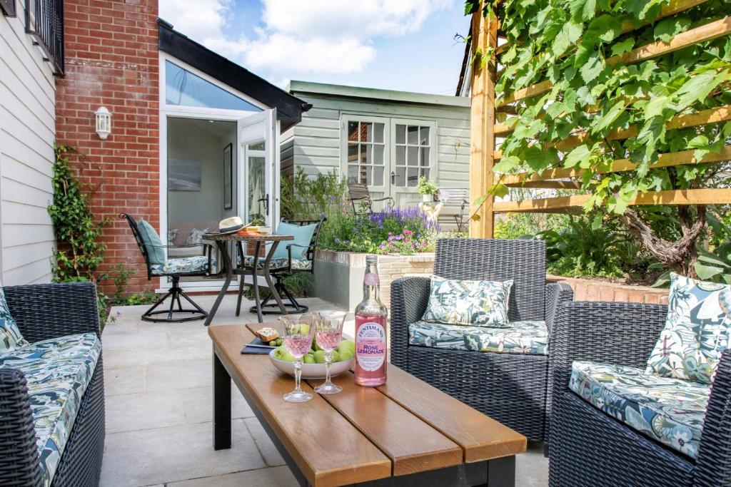 a patio with chairs and a table with a bottle of wine at The Boathouse in Waldringfield