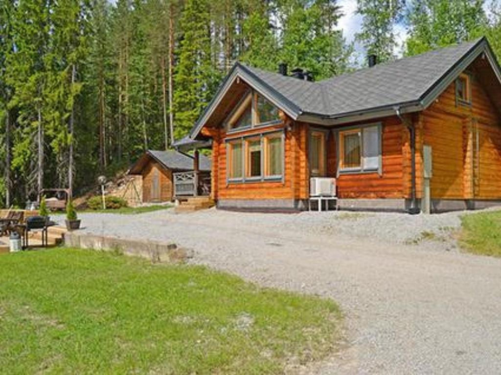 a log cabin in the woods with a driveway at Holiday Home Rantamaja by Interhome in Kittilä