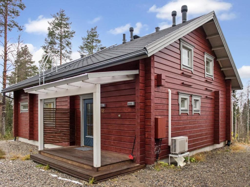 a red house with a porch and a deck at Holiday Home Sopukka by Interhome in Vuokatti