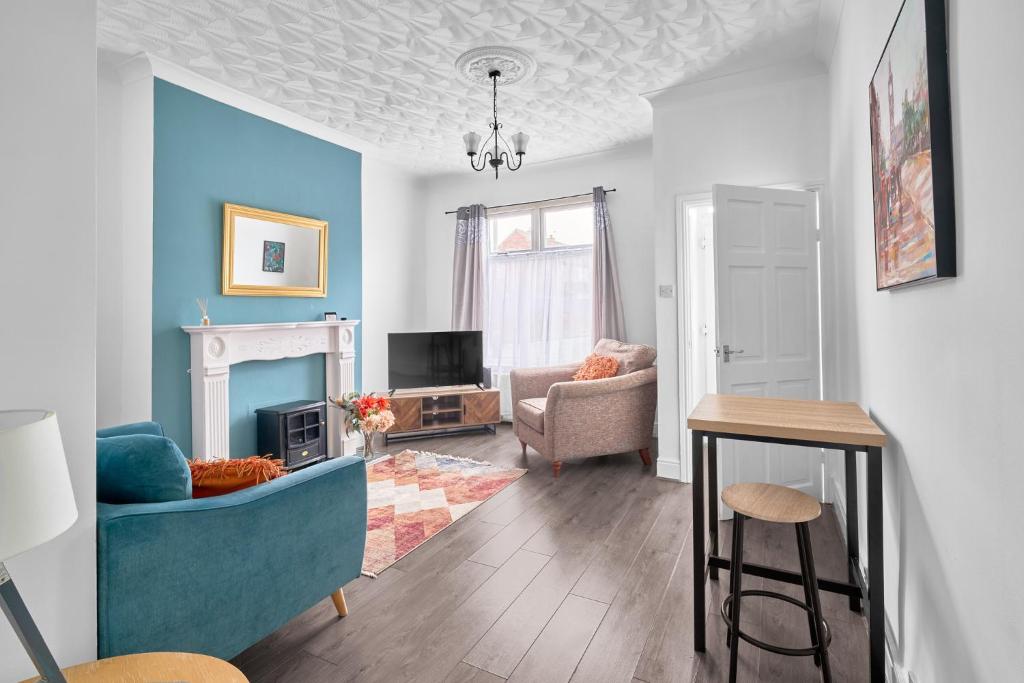 a living room with a blue couch and a chair at Suggitt House in Hartlepool