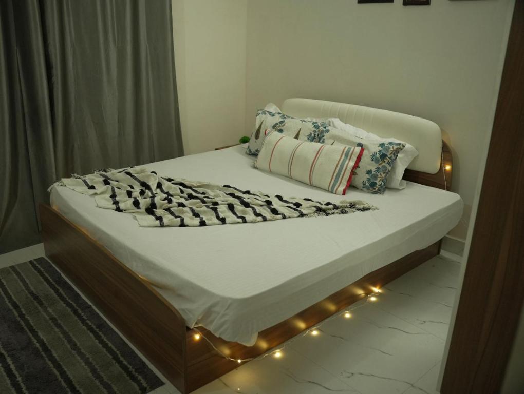 a bed with lights on it in a room at Nirvaan Nest in Faridabad