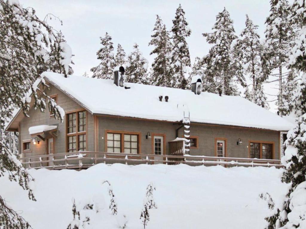 a house covered in snow in the woods at Holiday Home Kivalonmaa a by Interhome in Äkäslompolo