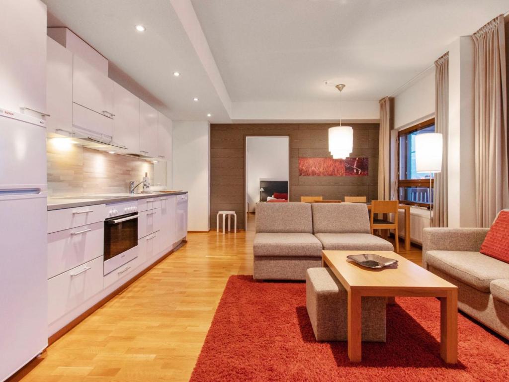 a kitchen and living room with a couch and a table at Holiday Home Ski chalets 6405 by Interhome in Ylläsjärvi