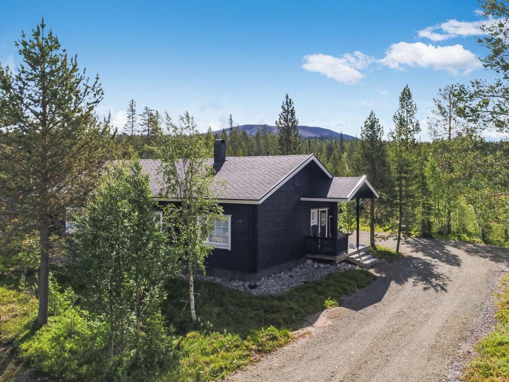 a home in the woods with a dirt road at Holiday Home Tuulenpuuska by Interhome in Äkäslompolo
