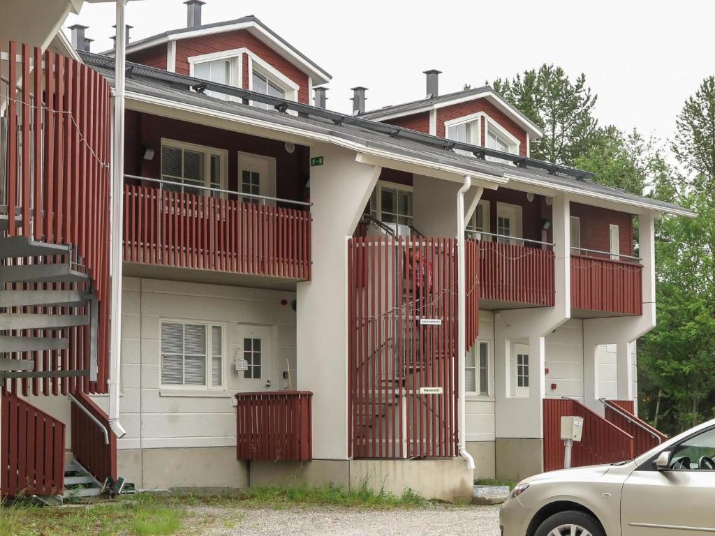 a house with red balconies and a car parked in front at Holiday Home Levi star 1009 by Interhome in Levi