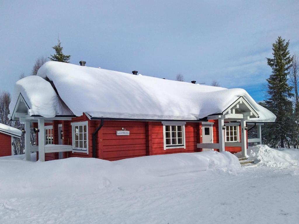 a red cabin with snow on top of it at Holiday Home Vuonkuma by Interhome in Äkäslompolo
