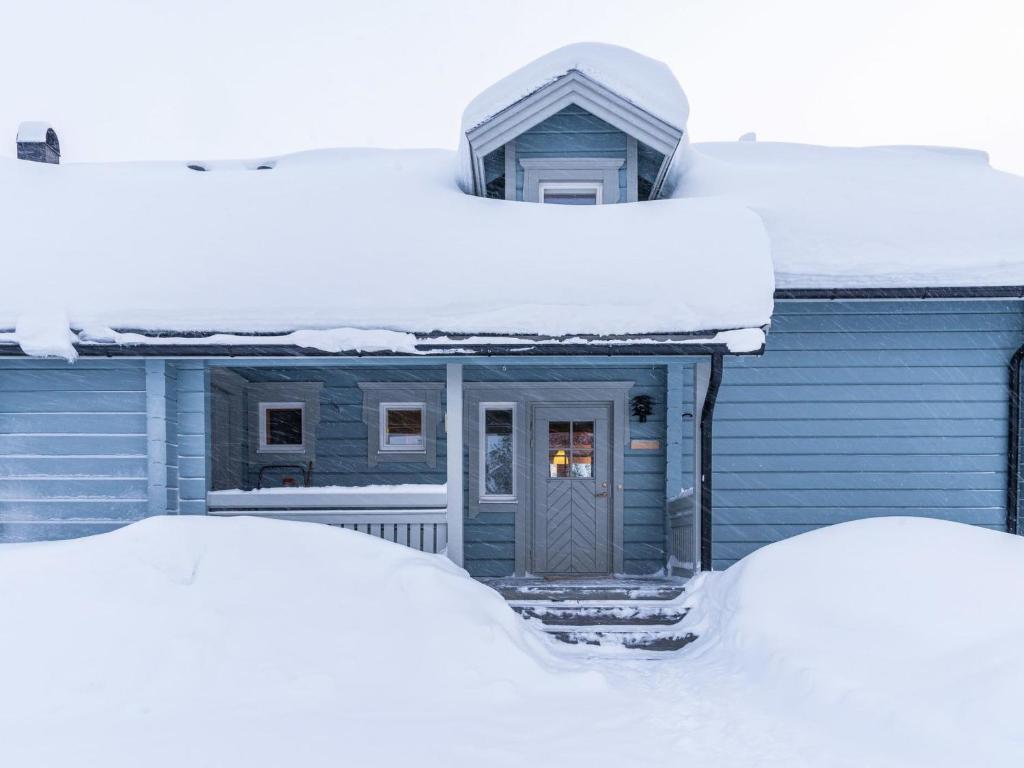a blue house with snow on top of it at Holiday Home Aamutähti by Interhome in Äkäslompolo