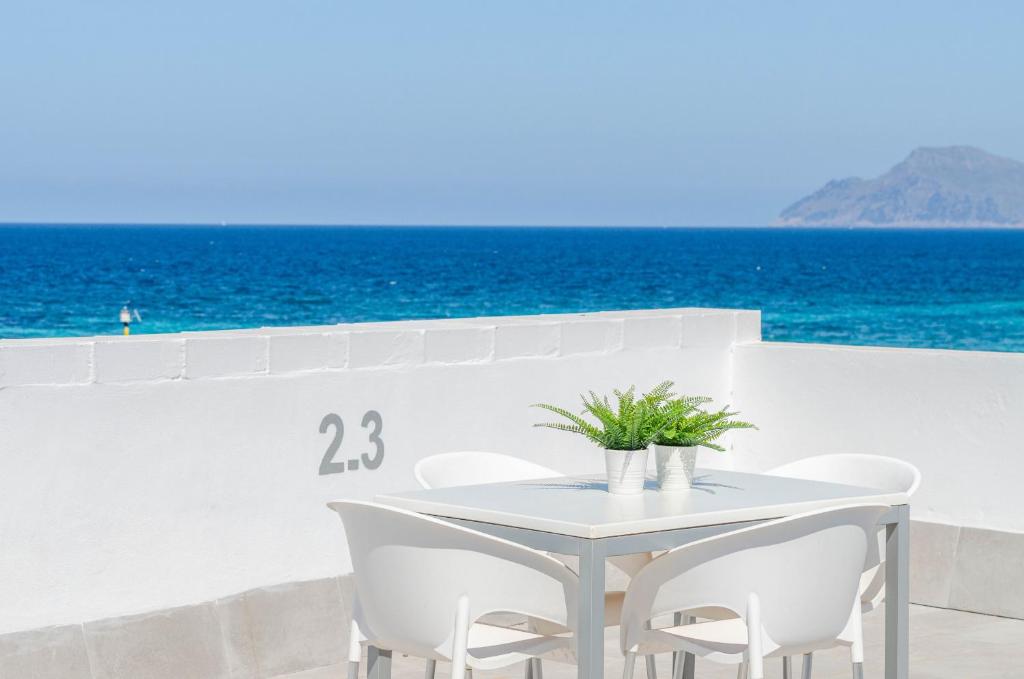 a white table and chairs with the ocean in the background at Yourhouse Blau Blue 2 3 in Can Picafort
