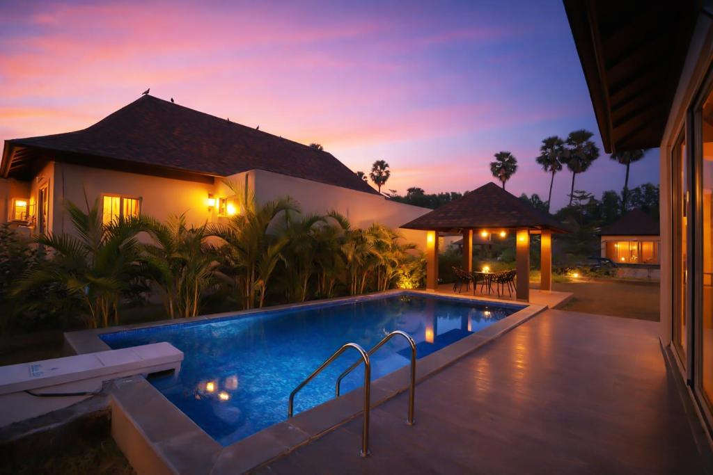 a villa with a swimming pool at night at Daksh The Nirvana Retreat in Vitoj