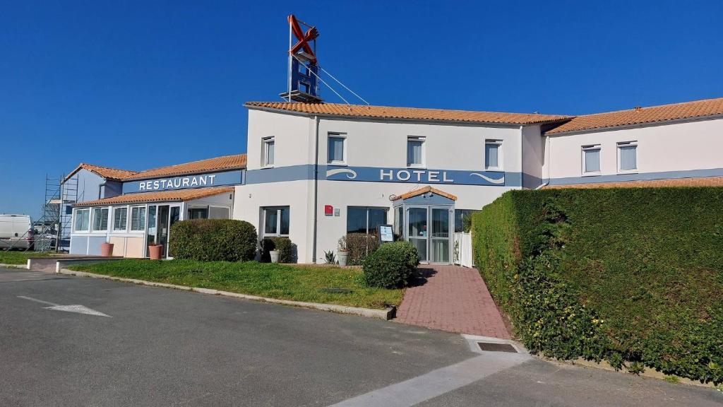 a hotel with a sign on the front of it at Logis Hôtel L'Air Marin in Yves