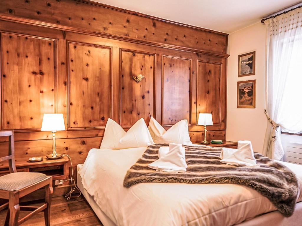 a bedroom with a large bed with a wooden wall at Apartment Chesa Sonnalpine B 48-4 by Interhome in St. Moritz