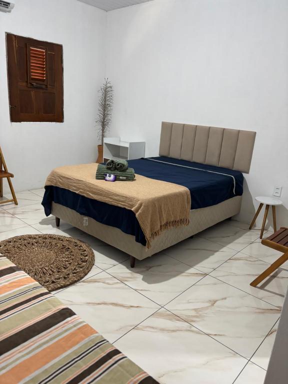 a bedroom with a bed and a floor with a rug at Cajuí da Vila Atins in Atins