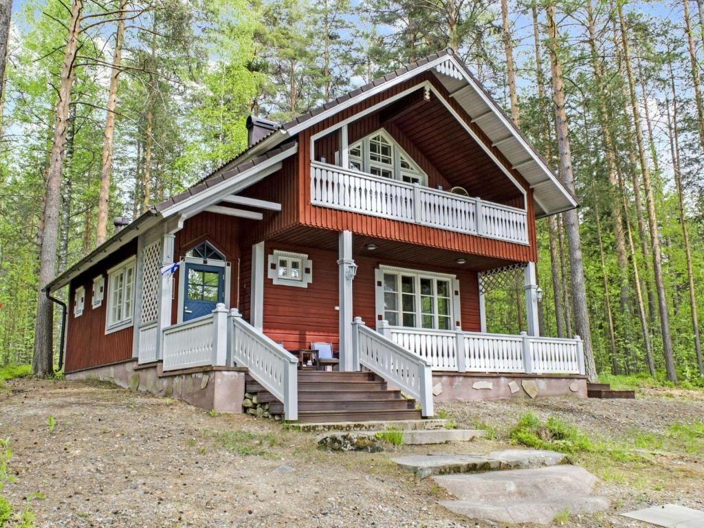 a log cabin in the woods with a porch at Holiday Home Honkaniemi by Interhome in Rasivaara