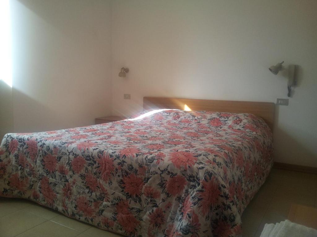 a bedroom with a bed with a floral bedspread at La Colombella in Montemonaco