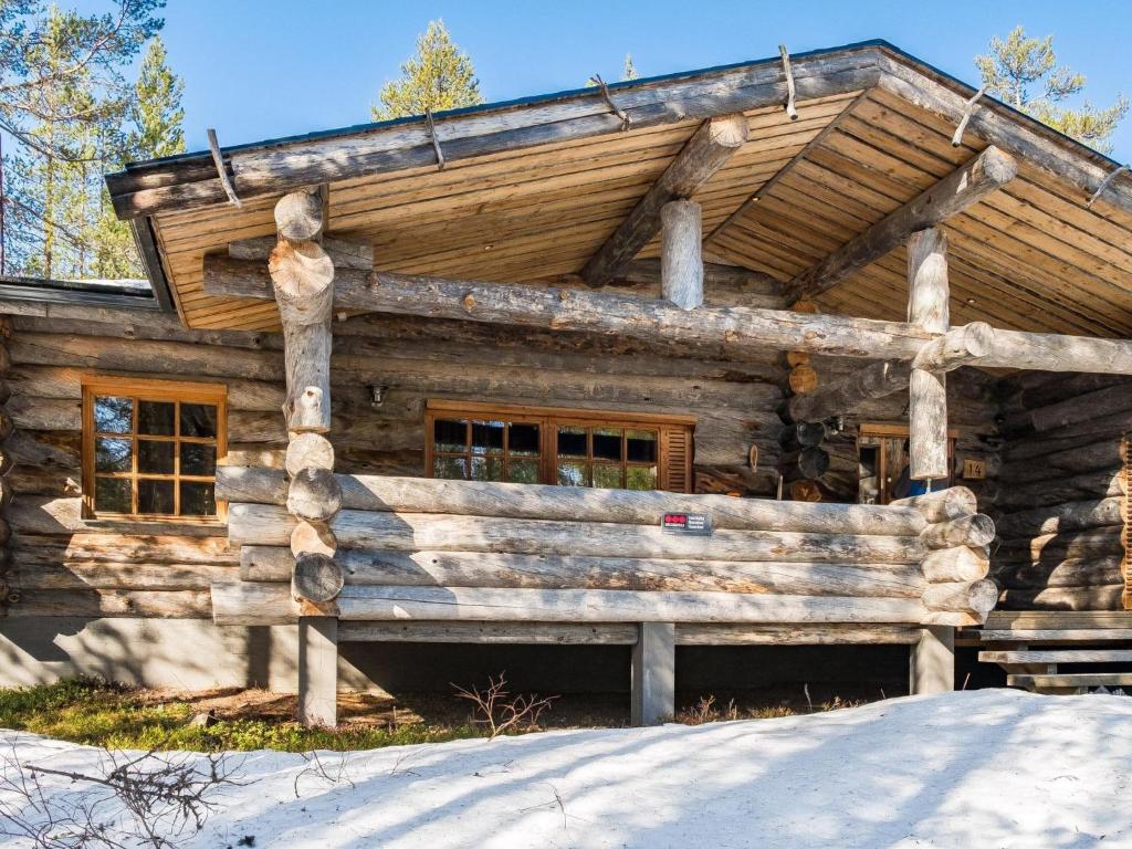 a log cabin in the woods with snow around it at Holiday Home Suutarinkolo by Interhome in Levi