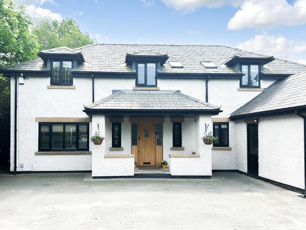 a large white house with a wooden door at Castlebar in Little Singleton