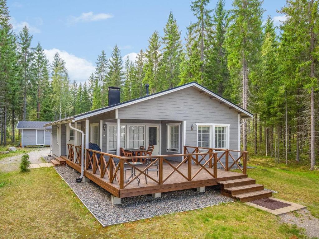 a tiny house in the woods with a large deck at Holiday Home Kaisla by Interhome in Pertunmaa