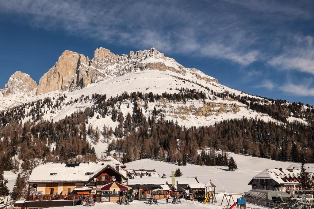 a ski lodge in front of a mountain at Bar-Restaurant-Pizzeria Antermont B&B in Carezza al Lago