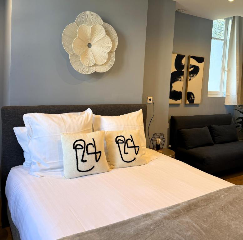 a bedroom with a bed with two pillows on it at Hôtel La Réserve de Brive in Brive-la-Gaillarde