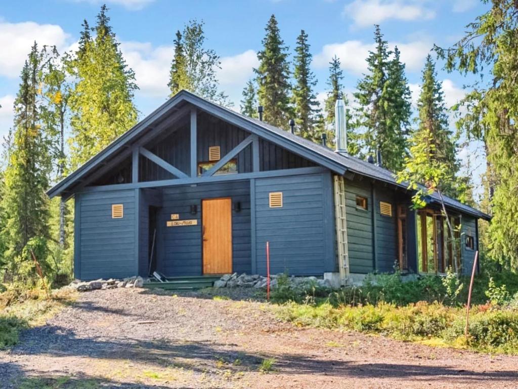 a house with a garage in the woods at Holiday Home Sinikuono by Interhome in Ylläsjärvi