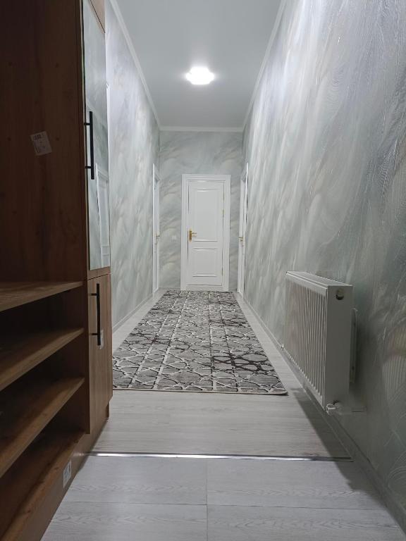 a hallway with a white door and a tile floor at Bobur Guest House in Khiva