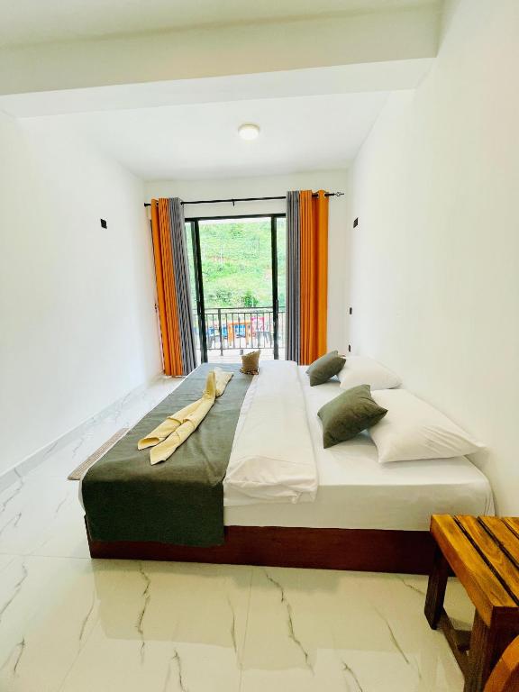 a large bed in a room with a large window at Ella 78 Resort in Ella