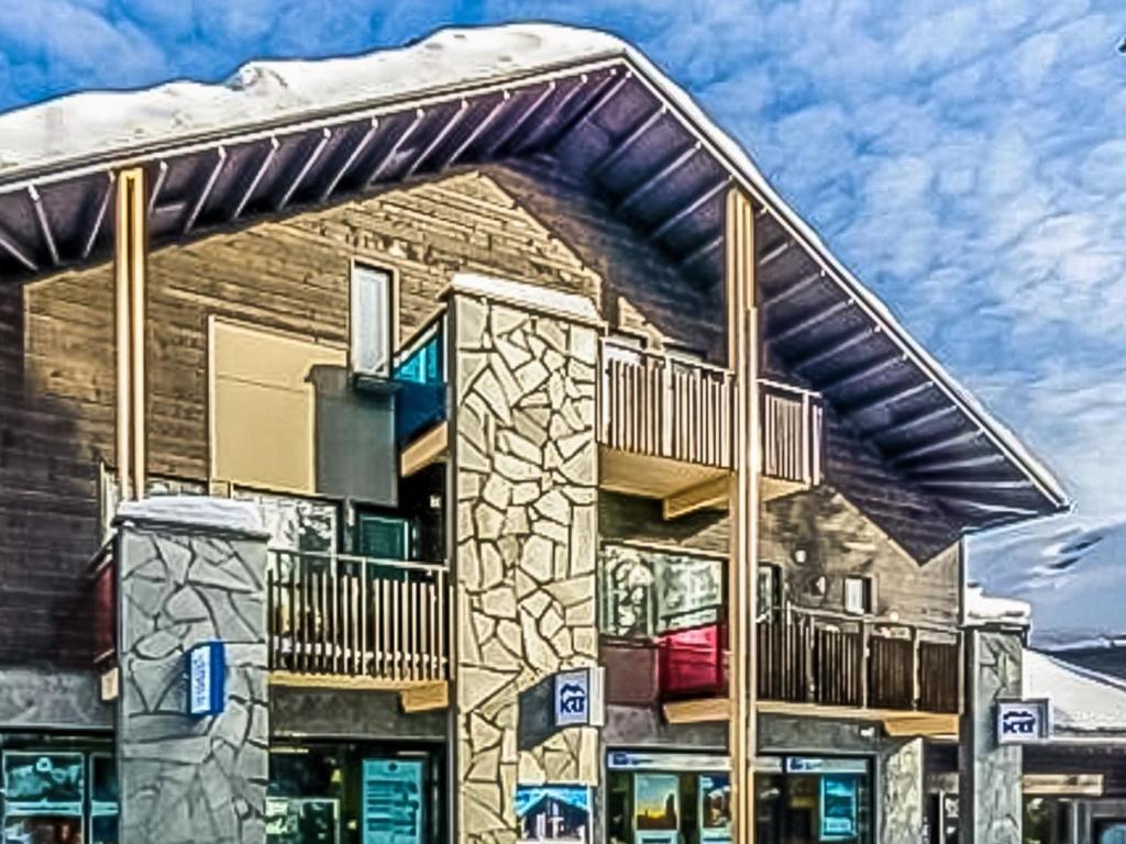 a building with a balcony and a snow covered roof at Holiday Home Levin stara c11 by Interhome in Levi