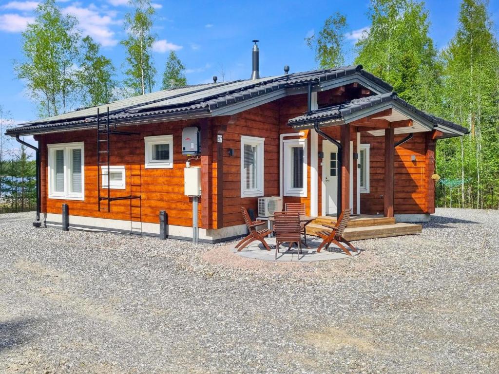 a small wooden cabin with a table and chairs at Holiday Home Nummentähti by Interhome in Tammela