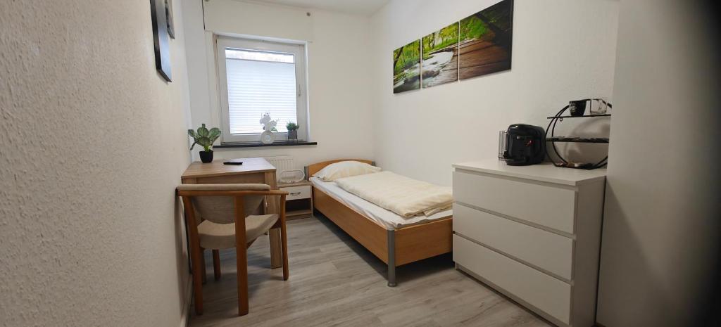 a small room with a desk and a bed and a table at Gasthof Hochstein in Meschede