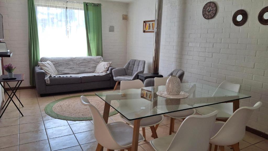 a living room with a glass table and chairs at Casa Huedhued in Villarrica