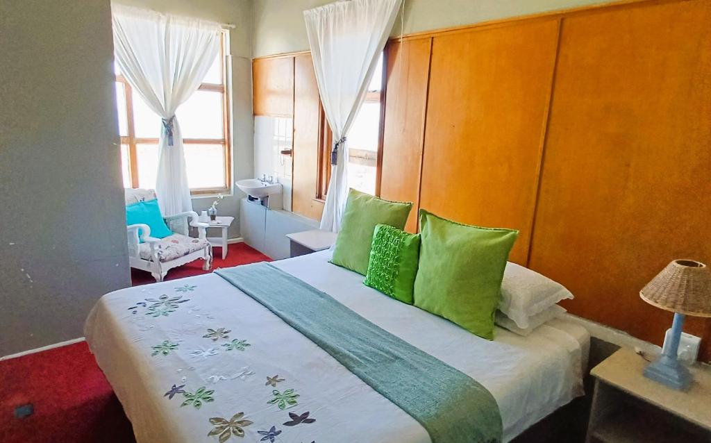 a bedroom with a large bed with green pillows at Oceanic Flashpackers accommodation in East London