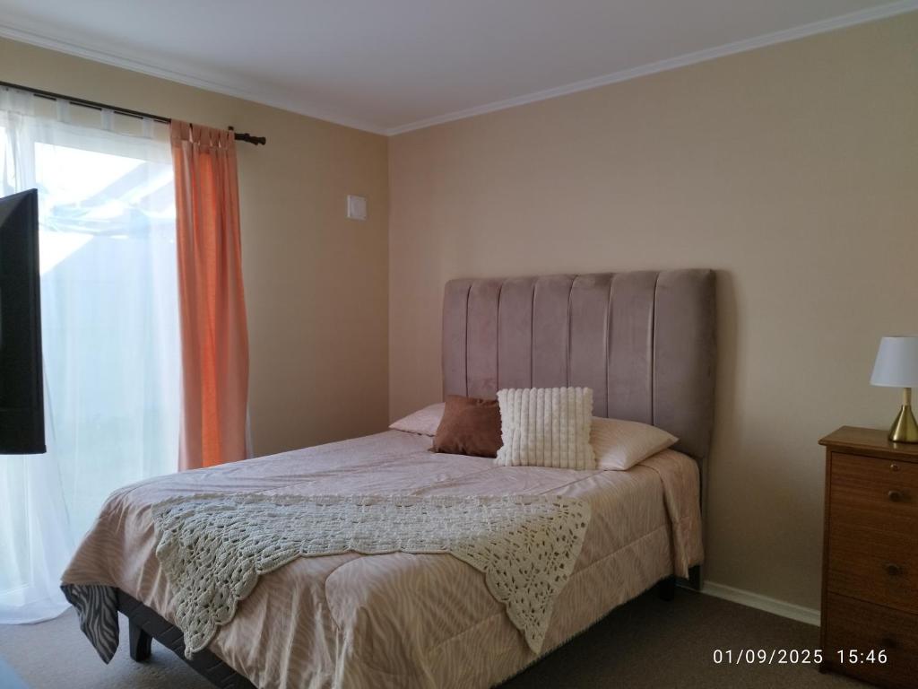 a bedroom with a bed and a window at Casa CQ in Coquimbo