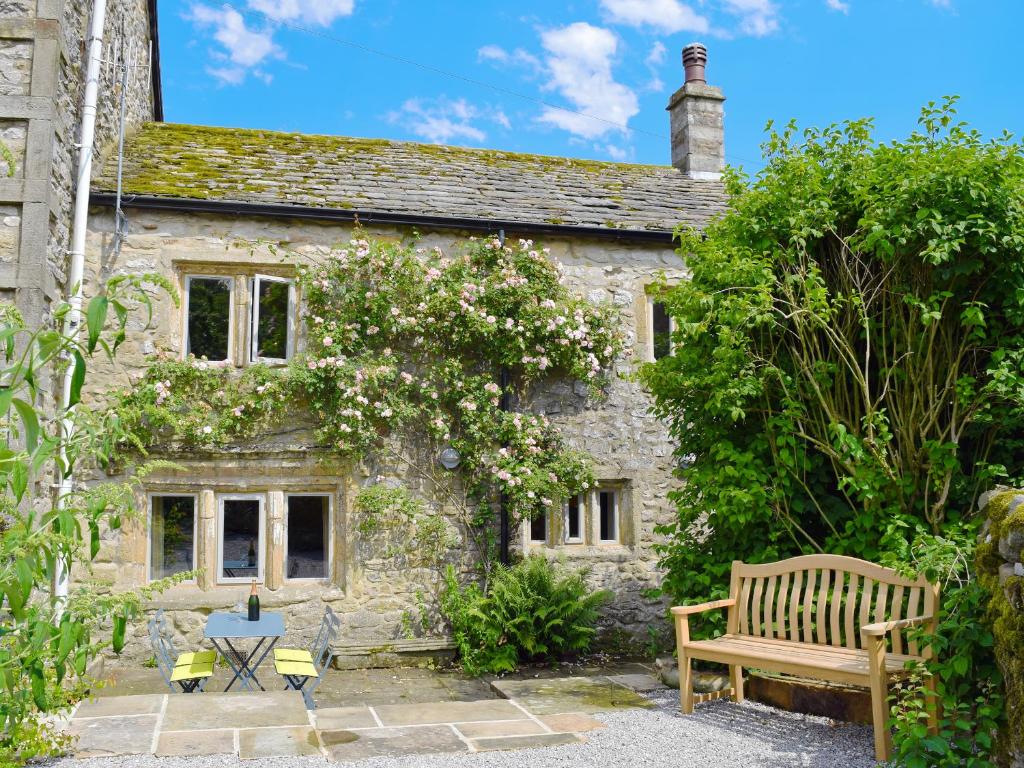 a stone house with a bench in front of it at Prospect Cottage in Kettlewell