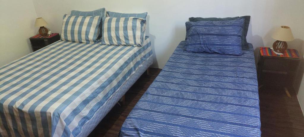 two beds sitting next to each other in a bedroom at Quarto Suíte Pitanga in Atibaia