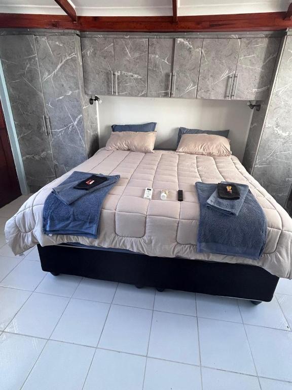 a bed with two blue towels on top of it at 52 Maroela street in Mossel Bay