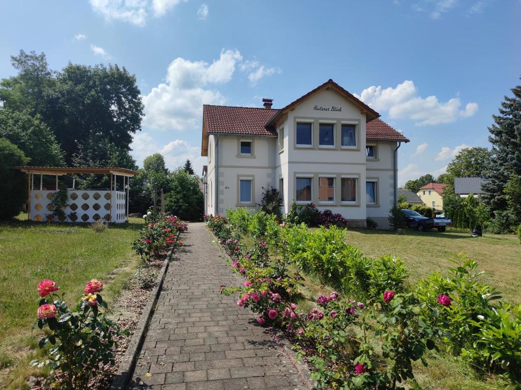 a white house with flowers in front of it at Eine gemütliche Ferienwohnung in Kurort Gohrisch