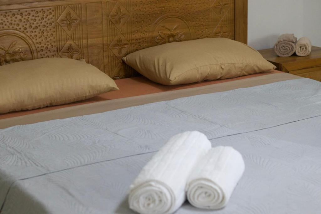 a bed with two rolls of white towels on it at Beny SeaBeach Residence in Belle Mare