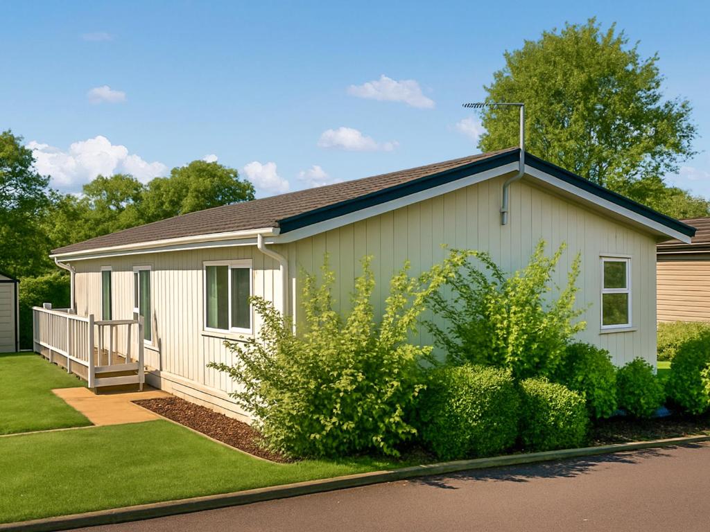 a small white building with a porch and some bushes at Highview in North Walsham