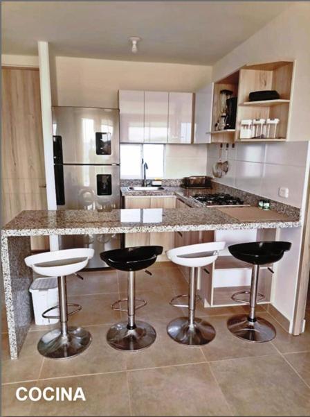 a kitchen with a counter with bar stools in it at Capriella,Cartagena in Cartagena de Indias