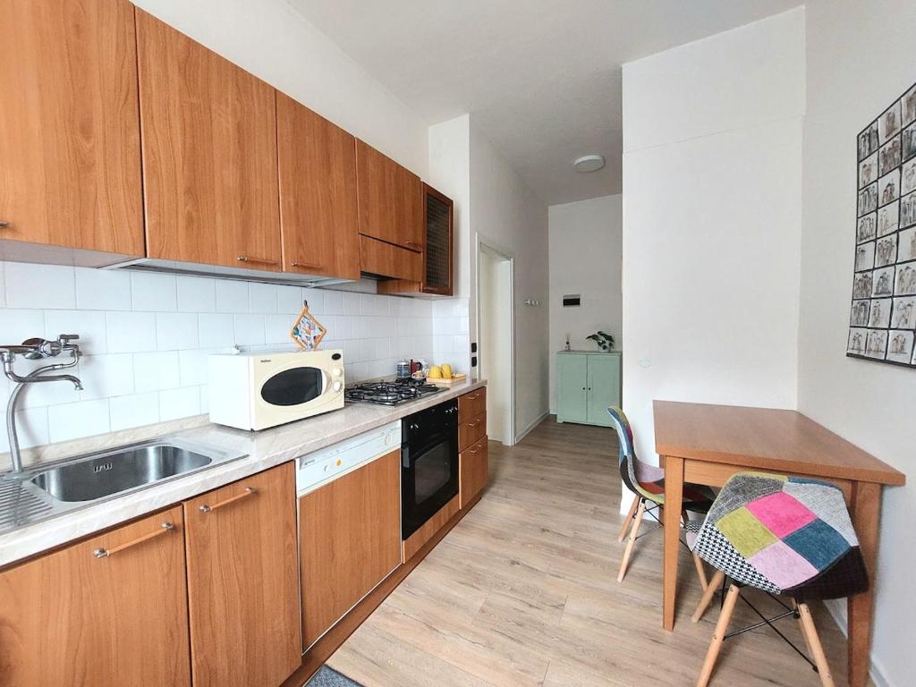 a kitchen with a sink and a table with a microwave at Grazioso Bilocale in Busto Arsizio